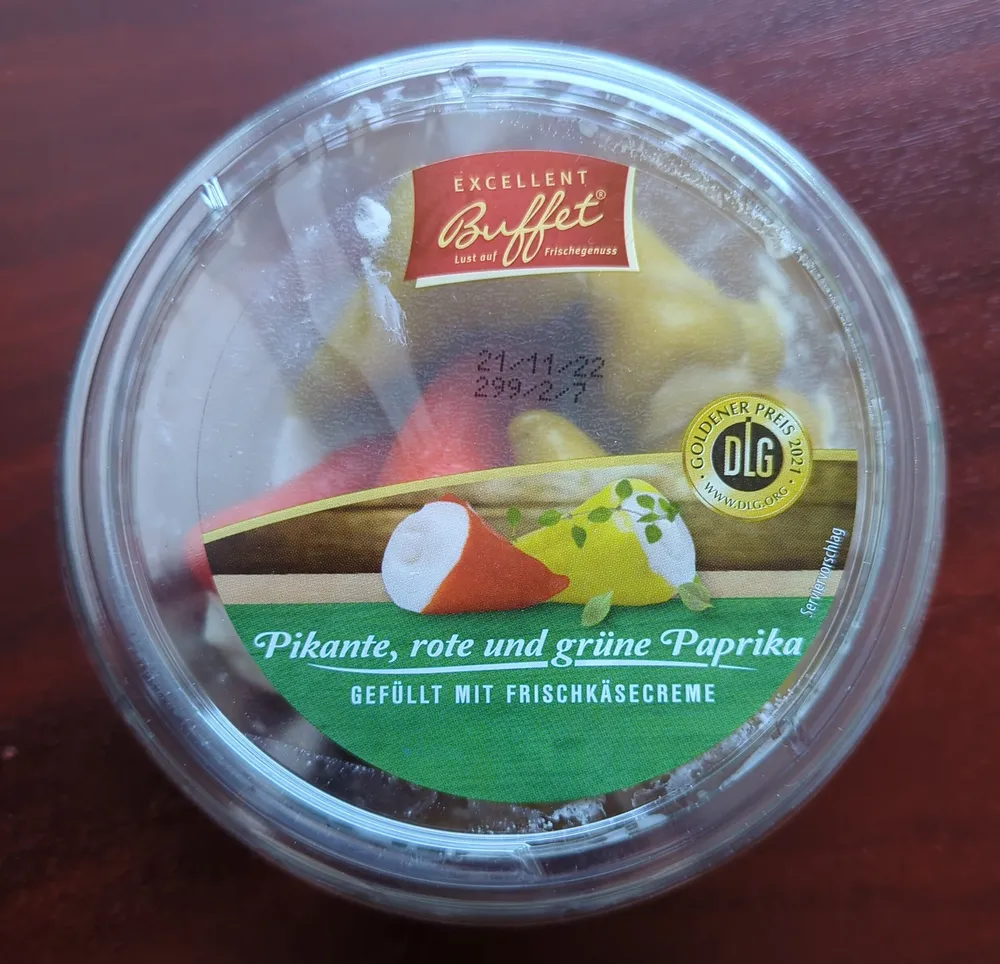Pikante, rote und grüne Paprika gefüllt mit Frischkäse