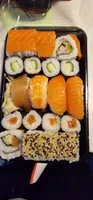 Sushi: 8x Maki (4x Lachs, 4x Gurke); 4x Nigiri (2x Lachs, 1x Thunfisch, 1x Garnele); 8x California (4x mit Lechs, Gurke; 4x mit Lachs, Surimi, Avocado). Bellage: Eingelegter Ingwer (10 g).