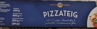 Pizzateig auf Backpapier mit Tomatensauce