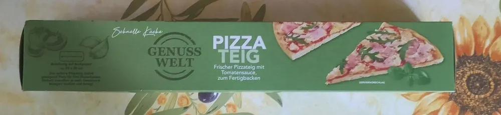 Pizzateig auf Backpapier mit Tomatensauce