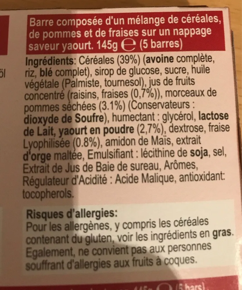 Barre composée d'un mélange de céréales, de pommes et de fraises sur un nappage saveur yaourt