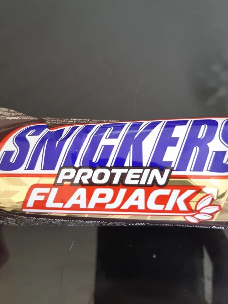 Barre à l'avoine riche en protéines avec une couche de caramel et arachides enrobées de chocolat au lait