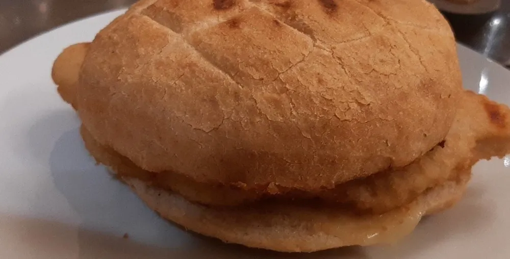 Panino farcito con cotoletta di pollo, formaggio edamer e maionese in bustina