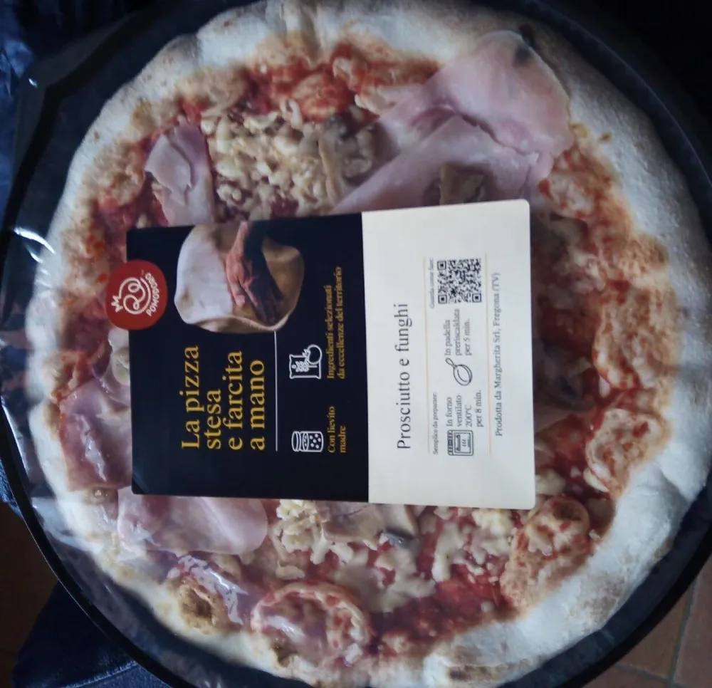 La pizza stesa e farcita a mano-prosciutto e funghi