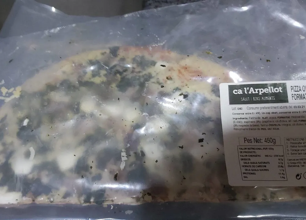 Pizza oval amb quinoa, espinacs, formatge de cabra i panses