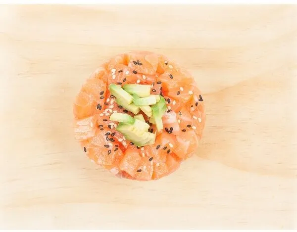 Tartar de salmón con aguacate, cebollino, pimienta y semillas de sésamo sobre base de arroz